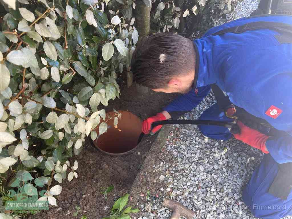 Monteur reinigt een rioolput met een slang, periodieke rioolreiniging in Emmeloord