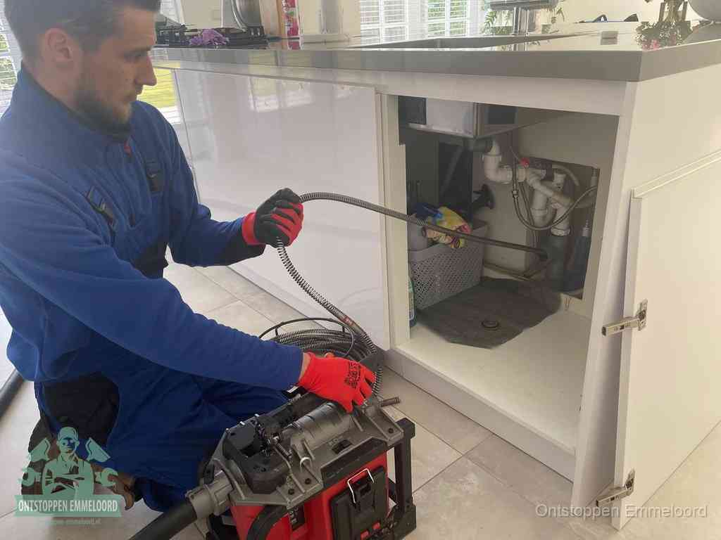 Een monteur reinigt de keukenafvoer grondig met een veermachine om terugkerende gootsteenverstoppingen te voorkomen in Emmeloord