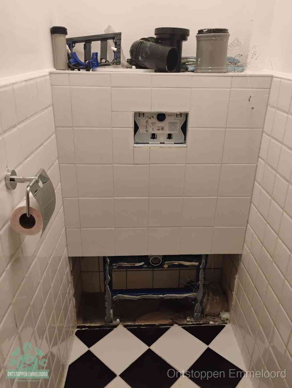 Een toiletruimte waar het hangtoilet en de inbouwreservoir-onderdelen zijn vrijgelegd voor onderhoud, periodiek nazicht voorkomt een wc-verstopping in Emmeloord